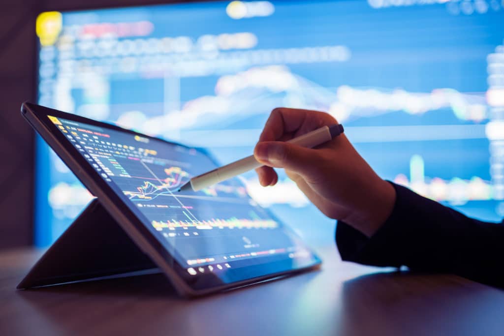 Woman looking stock market data on tablet